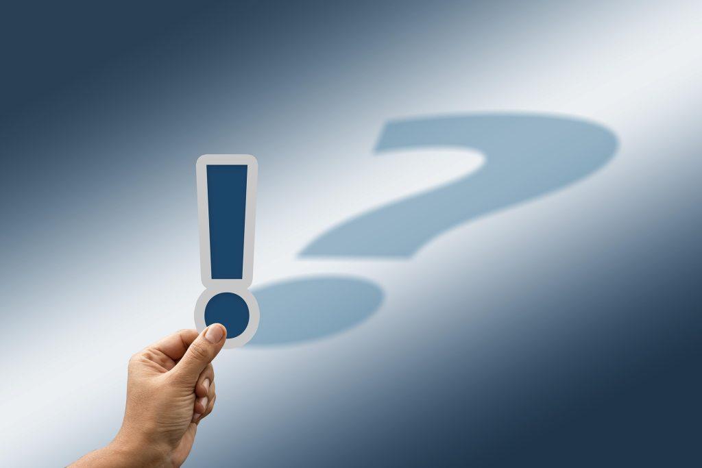 Point d'exclamation avec une ombre en forme de point d'interrogation pour appuyer l'importance d'un bon syndic de copropriété